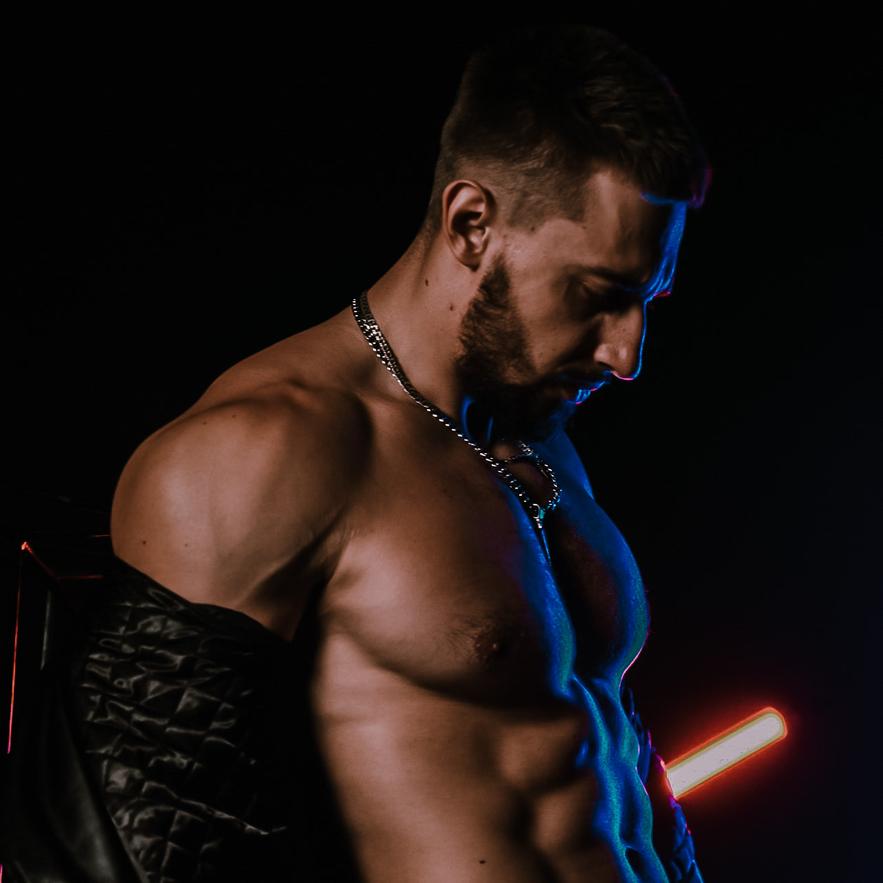 Vlad Belous in the studio, wearing a silver necklace and a black jacket over his shoulders